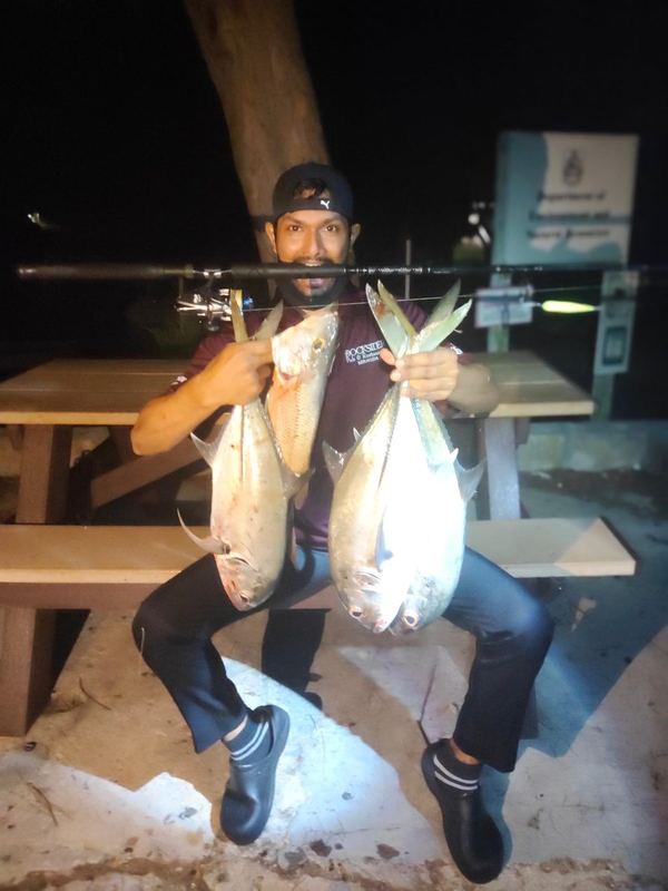 Customer seated holding two fish caught after dark