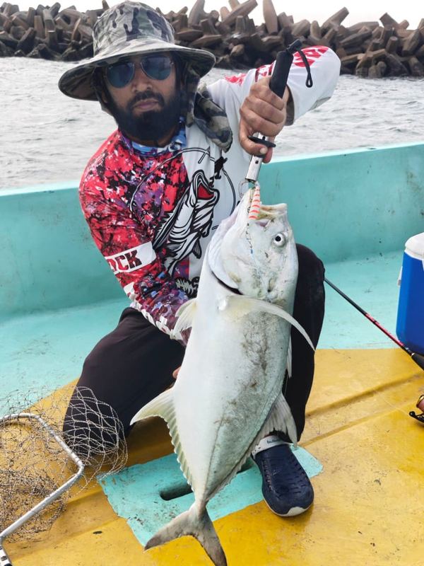 Customer on a boat holding a queenfish