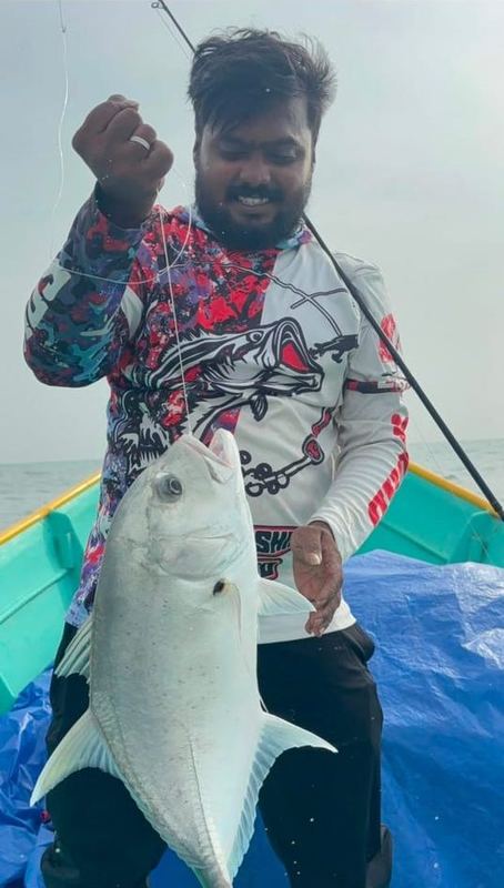 Customer on a boat holding a trevally